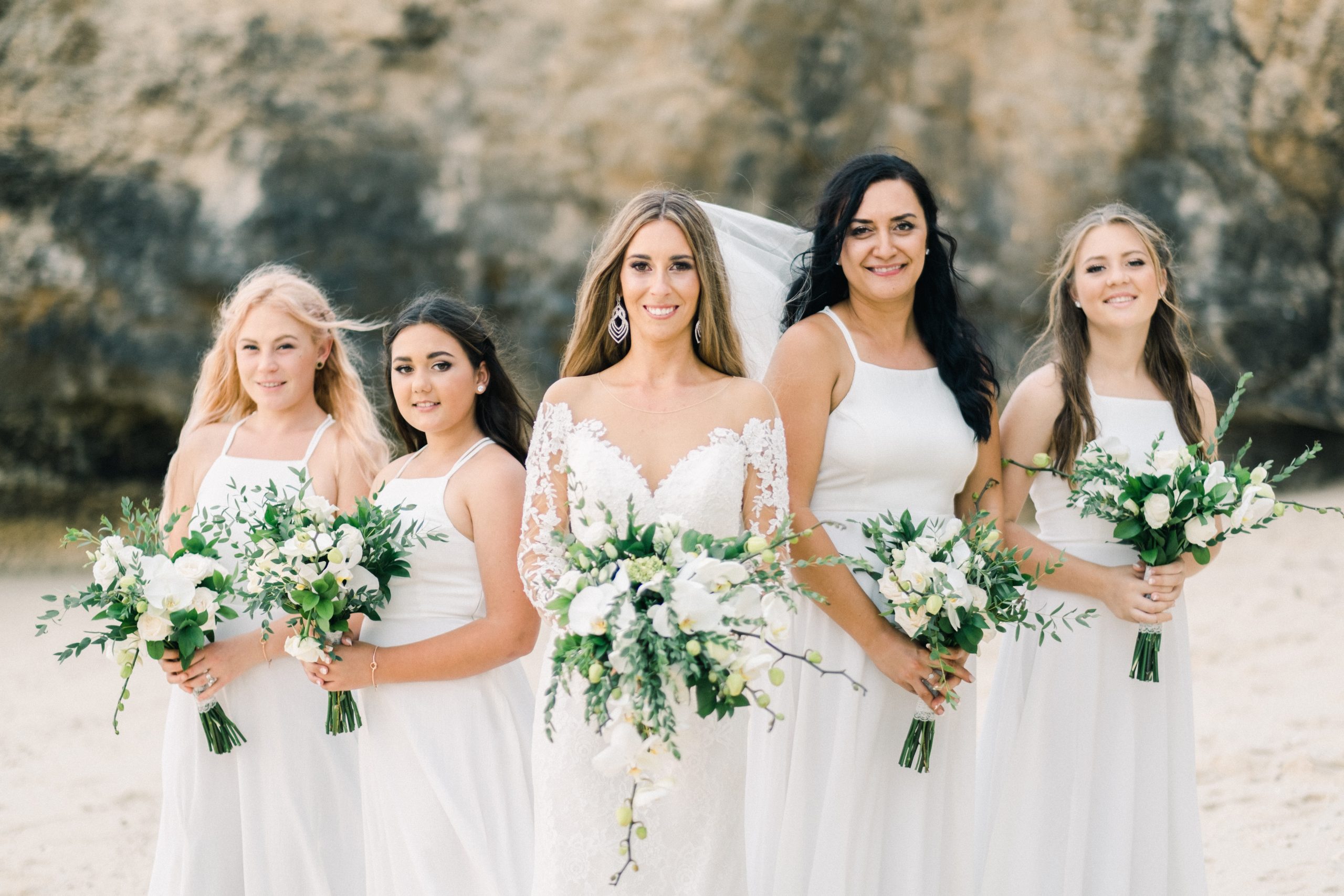 Bridesmaids Hayley and Paul holding wedding bouquets during their Hai Tide Beach Wedding at Hai Tide Beach Resort Nusa Lembongan Bali.